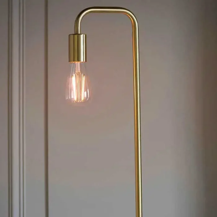 Floor lamp in a brushed brass finish showcases a clean line design