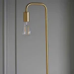 Floor lamp in a brushed brass finish showcases a clean line design