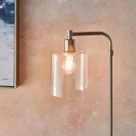 Floor lamp in a brushed nickel finish with clear glass shade