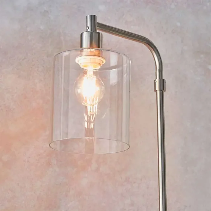 Floor lamp in a brushed nickel finish with clear glass shade