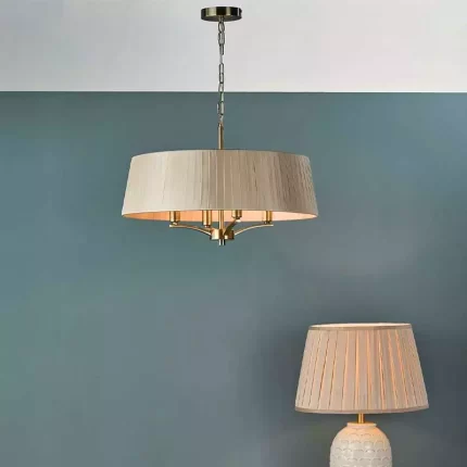 Pendant light with taupe shade in antique brass finish