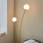 Floor lamp in brushed gold finish with white glass shades