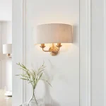 Wall light in aged brass finish with natural linen fabric shade