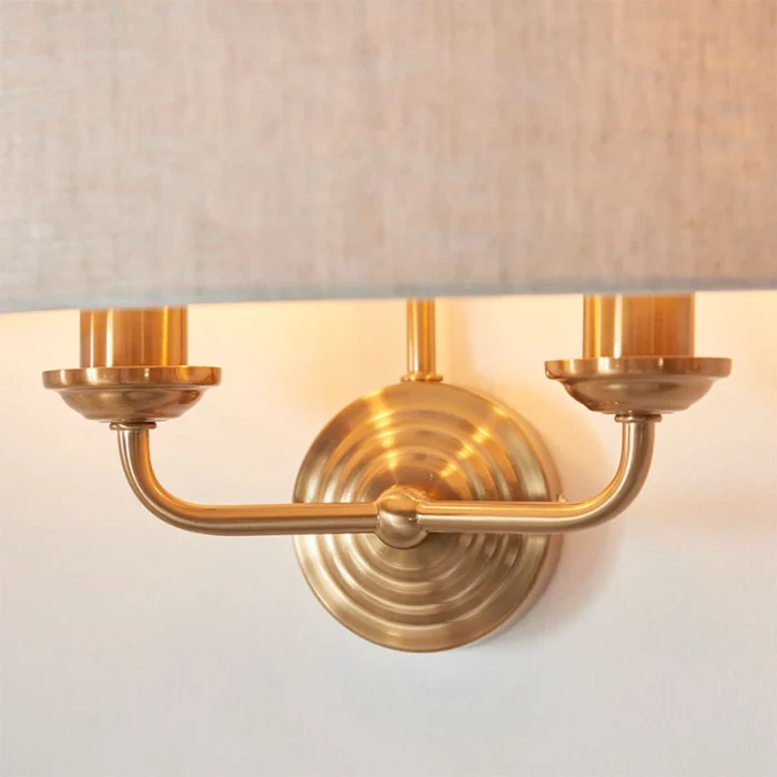 Wall light in aged brass finish with natural linen fabric shade