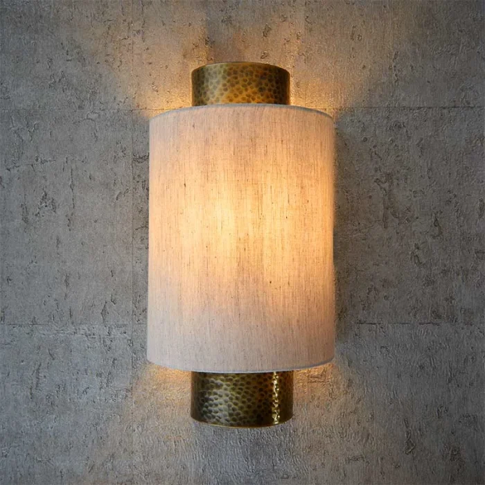 Wall light in aged bronze finish with natural fabric shade