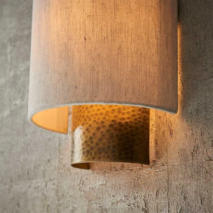 Wall light in aged bronze finish with natural fabric shade