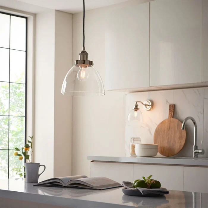 Single pendant light in bright nickel finish with clear glass shade