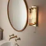 Bathroom wall light in brushed gold finish with clear glass shade