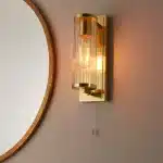 Bathroom wall light in brushed gold finish with clear glass shade