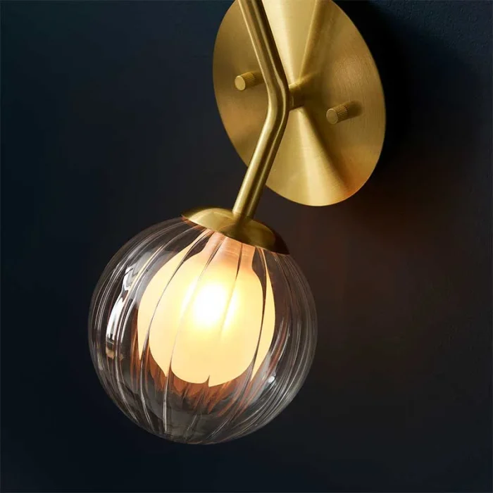 Wall light in satin brass finish with clear ribbed glass