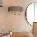 Multi arm bright nickel pendant light above dining table