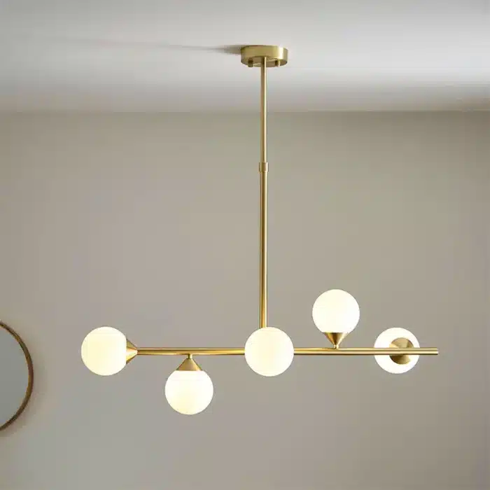 Satin brass linear pendant light with gloss opal glass shades lifestyle