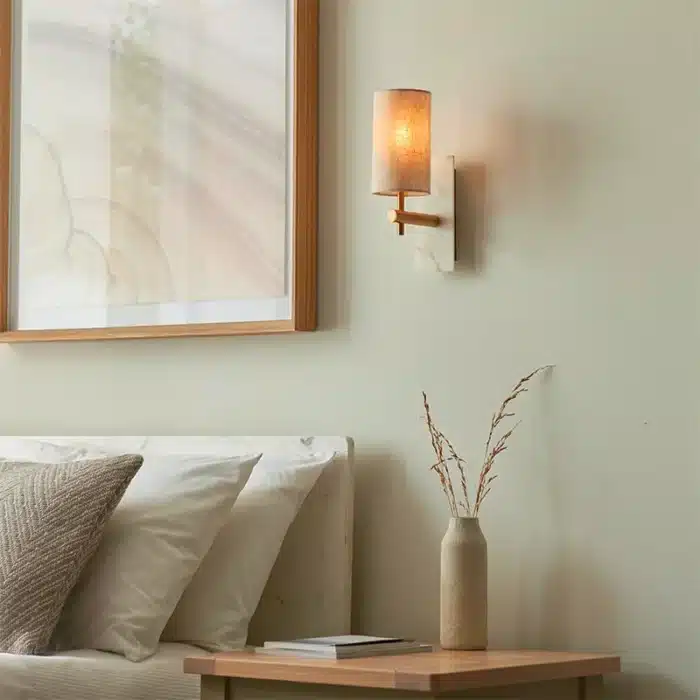 Brass marble effect wall light with linen shade in bedroom