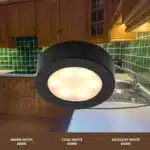 Matt black round LED under cabinet light in kitchen